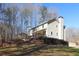 Well-maintained two-story home with neutral siding and a chimney, surrounded by lush trees at 165 Carriage Gate Dr, Sharpsburg, GA 30277