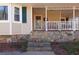 Inviting front porch with a cozy swing and stone accents, creating a charming and relaxing outdoor space at 165 Carriage Gate Dr, Sharpsburg, GA 30277