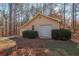 Detached one-car garage with neutral siding surrounded by green bushes and tall trees at 165 Carriage Gate Dr, Sharpsburg, GA 30277