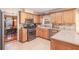 Bright kitchen features oak cabinetry, stainless steel appliances, and a tile backsplash at 165 Carriage Gate Dr, Sharpsburg, GA 30277