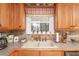 Charming kitchen featuring a window over the sink and rustic style cabinetry with granite countertops at 165 Carriage Gate Dr, Sharpsburg, GA 30277