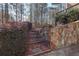 Landscaped path featuring stone steps, rock retaining wall, and lush bushes at 165 Carriage Gate Dr, Sharpsburg, GA 30277