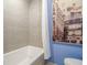 Modern bathroom showcasing gray tiled walls, bathtub, and blue accent wall with art at 249 The South Chace Ne, Atlanta, GA 30328