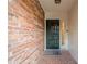 Covered front porch with brick flooring, a welcome mat, and a dark front door at 249 The South Chace Ne, Atlanta, GA 30328
