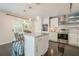 Bright kitchen with white cabinets, stainless steel appliances, island with marble countertop, and a sliding door at 249 The South Chace Ne, Atlanta, GA 30328