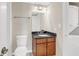 Cozy bathroom featuring a wood vanity, black countertop, toilet, and a convenient in-unit stacked washer and dryer at 275 13Th Ne St # 903, Atlanta, GA 30309