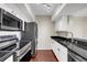Updated kitchen features stainless steel appliances, sleek dark countertops, and hardwood flooring at 275 13Th Ne St # 903, Atlanta, GA 30309