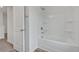 All-white bathroom featuring a tub and shower combo with built in shelving and bright lighting at 376 Waterbluff Dr, Mableton, GA 30126
