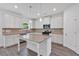 A well-appointed kitchen features an island, hard surface floors, and white cabinets and stainless appliances at 376 Waterbluff Dr, Mableton, GA 30126