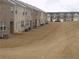 Backyard view of brick townhomes with well maintained lawns and exteriors on a cloudy day at 1302 Speckle Park Way, Stockbridge, GA 30281