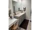 Bathroom with a large mirror, double sinks, vanity, and dark mat on tile floor at 1302 Speckle Park Way, Stockbridge, GA 30281