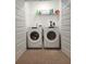 Convenient laundry room featuring stacked washer and dryer units and storage shelves at 1302 Speckle Park Way, Stockbridge, GA 30281