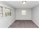 An empty bedroom with gray walls and carpet, featuring two bright windows at 1507 Fair Haven Dr, Riverdale, GA 30296