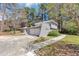 The charming home is surrounded by mature trees and lush greenery at 1507 Fair Haven Dr, Riverdale, GA 30296