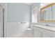 Bathroom featuring a modern vanity, tiled walls, glass block window, and a shower at 2265 E Lake Ne Rd, Atlanta, GA 30307