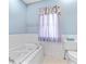 Bright bathroom features a soaking tub, toilet, and a window with privacy curtain at 2265 E Lake Ne Rd, Atlanta, GA 30307