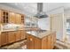 Updated kitchen featuring custom cabinets, stone floors, stainless hood, and an island cooktop at 2265 E Lake Ne Rd, Atlanta, GA 30307