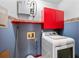 A compact laundry room with blue walls, red accents, and an efficient front-loading washer at 2265 E Lake Ne Rd, Atlanta, GA 30307