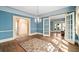 Light filled living room featuring blue walls, hardwood floors, chandelier, and french doors at 2265 E Lake Ne Rd, Atlanta, GA 30307