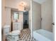 Bathroom with a tub, toilet, sink and gray tile accent wall. Has patterned flooring at 2836 Waters Sw Rd, Atlanta, GA 30354
