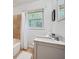 Bathroom featuring a window with natural light, single sink vanity with a white countertop and bath with tile surround at 2836 Waters Sw Rd, Atlanta, GA 30354