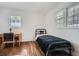 A bedroom features hardwood floors, a dark-colored metal bed frame, desk and two windows at 2836 Waters Sw Rd, Atlanta, GA 30354