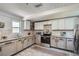 A kitchen features wooden floors, stainless steel appliances, granite counters, and white and tan cabinets at 2836 Waters Sw Rd, Atlanta, GA 30354