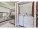 Kitchen area with white cabinets, stainless fridge and a laundry area with a stacked washer and dryer at 2836 Waters Sw Rd, Atlanta, GA 30354
