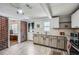 A kitchen features wooden floors, stainless steel appliances, granite counters, and white and tan cabinets at 2836 Waters Sw Rd, Atlanta, GA 30354