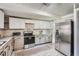 A kitchen features wooden floors, stainless steel appliances, granite counters, and white and tan cabinets at 2836 Waters Sw Rd, Atlanta, GA 30354
