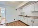 Small kitchenette with white cabinets, double sink, granite-look counter-top, and wood-look flooring at 2836 Waters Sw Rd, Atlanta, GA 30354