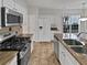 Well-maintained kitchen with stainless appliances, stone countertops, and tile backsplash at 3905 Delfaire Trce, Cumming, GA 30040