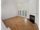 Bright living room with hardwood floors, fireplace, and French doors to the outside at 3905 Delfaire Trce, Cumming, GA 30040