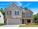 Beautiful two-story home featuring a brick facade, gray siding, a two-car garage, and a well-manicured lawn at 372 Waterbluff Dr, Mableton, GA 30126
