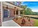 Inviting front porch with decorative pillars, manicured landscaping, and a stylish blue front door at 372 Waterbluff Dr, Mableton, GA 30126