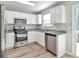 Modern kitchen with stainless steel appliances, granite countertops, and white cabinets at 344 Springbottom Ct, Lawrenceville, GA 30046