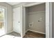 Bright laundry room features washer and dryer hookups, wire shelving and wood-look flooring at 344 Springbottom Ct, Lawrenceville, GA 30046