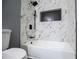 Contemporary bathroom featuring white marble-style tile in shower, modern fixtures, and an integrated black shower niche at 116 Carroll St, Temple, GA 30179