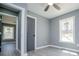 Neutral bedroom featuring light gray walls, updated floors, a ceiling fan and natural light from a window at 116 Carroll St, Temple, GA 30179
