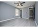 Bedroom with a ceiling fan, light gray walls, updated floors, and natural light from a window at 116 Carroll St, Temple, GA 30179