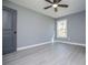Bedroom with a ceiling fan, light gray walls, updated floors, and natural light from a window at 116 Carroll St, Temple, GA 30179