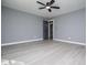 An open bedroom is shown with gray walls and vinyl flooring plus a ceiling fan at 116 Carroll St, Temple, GA 30179