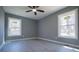 Neutral bedroom featuring light gray walls, updated floors, a ceiling fan and natural light from two windows at 116 Carroll St, Temple, GA 30179