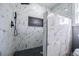Luxurious shower features marble tiling, black hardware, and hexagon tile floor at 116 Carroll St, Temple, GA 30179