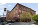 Exterior view of a brick building with green-trimmed windows and a water tower with lush landscaping around the building at 170 Boulevard Se # 104E, Atlanta, GA 30312