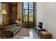 Living room with exposed brick wall, large window, high ceilings, and modern lighting at 170 Boulevard Se # 104E, Atlanta, GA 30312