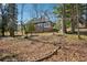 Backyard featuring a brick house amidst tall trees and foliage, enhanced by natural light at 2696 Dodson Dr, East Point, GA 30344