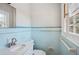 Charming bathroom features classic blue tiling, a modern vanity, and ample natural light from the window at 2696 Dodson Dr, Atlanta, GA 30344