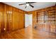 Bedroom features wood paneling and hardwood floors, complemented by a ceiling fan and built-in shelves at 2696 Dodson Dr, East Point, GA 30344
