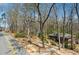 Street-level view shows a charming home with mature trees in a serene residential neighborhood setting at 2696 Dodson Dr, East Point, GA 30344